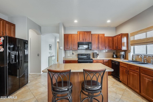17562 W Agave Ct, Goodyear, AZ 85338 - kitchen featuring black appliances, arched walkways, a sink, light countertops, and tasteful backsplash