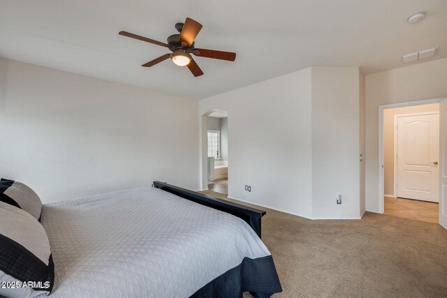 17562 W Agave Ct, Goodyear, AZ 85338 - bedroom featuring arched walkways, carpet, ceiling fan, baseboards, and ensuite bathroom