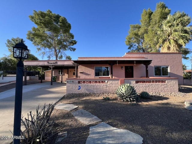 single story home with fence, a carport, stucco siding, and driveway