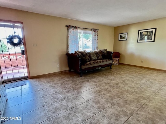 living room featuring baseboards and light tile patterned floors