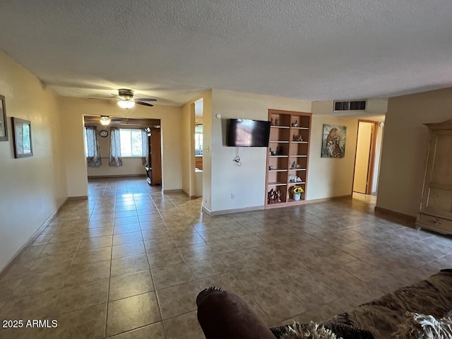 unfurnished living room with baseboards, visible vents, a ceiling fan, and a textured ceiling