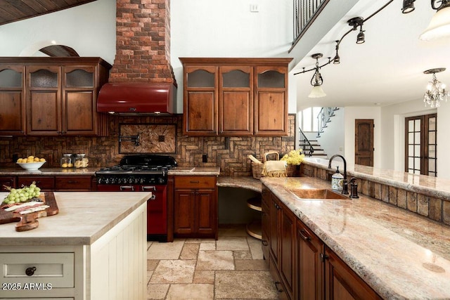 kitchen with stove, sink, pendant lighting, and backsplash