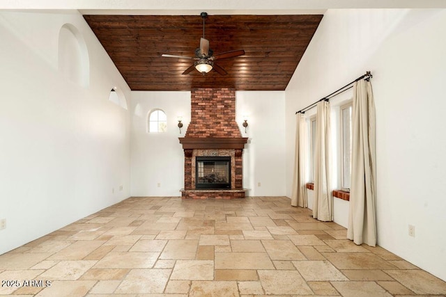 unfurnished living room with ceiling fan, a fireplace, and wooden ceiling