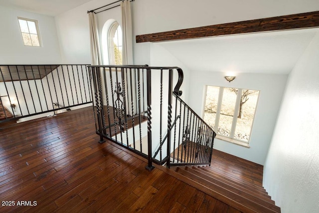 staircase with hardwood / wood-style flooring and lofted ceiling with beams