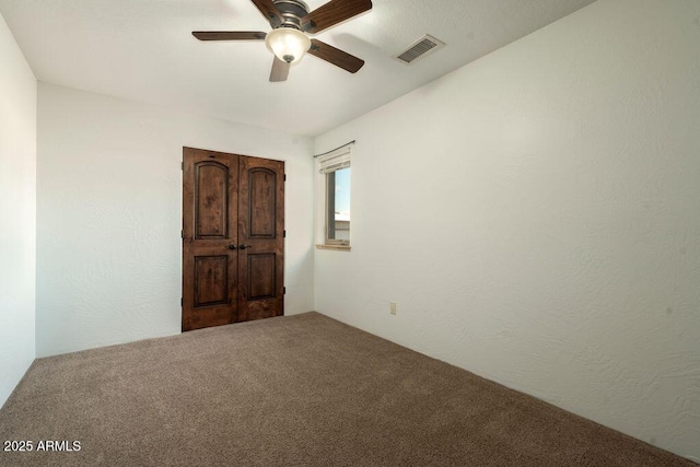 carpeted spare room with ceiling fan