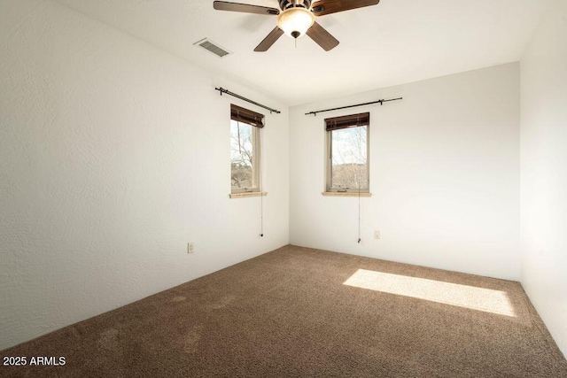 carpeted spare room featuring ceiling fan