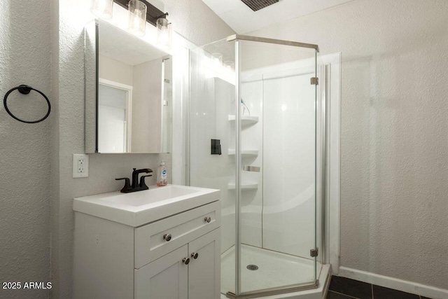 bathroom featuring vanity, tile patterned flooring, and a shower with door