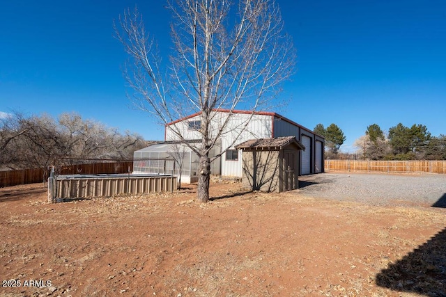 exterior space with a garage and an outbuilding