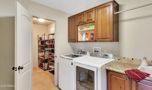 clothes washing area with cabinets and independent washer and dryer