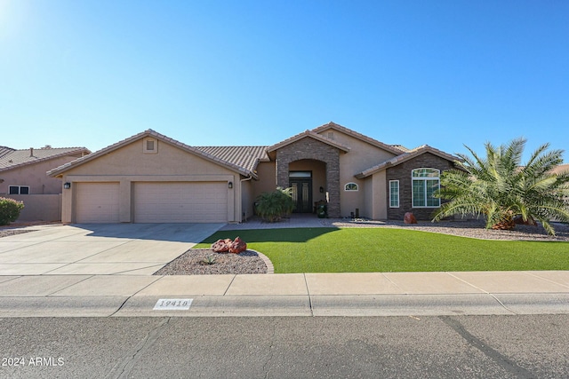 single story home with a front yard and a garage