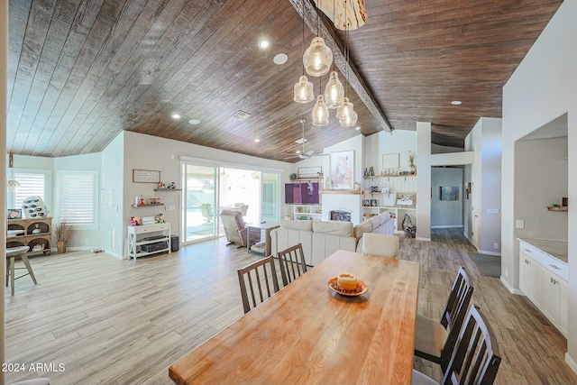 dining room featuring beam ceiling, light wood-type flooring, wood ceiling, and high vaulted ceiling