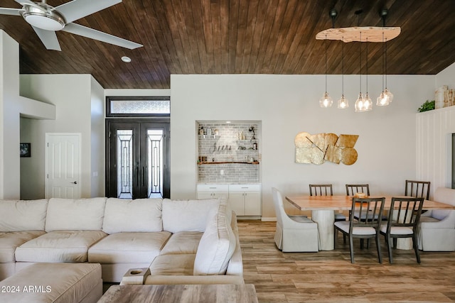 living room with ceiling fan, wood ceiling, and light hardwood / wood-style flooring