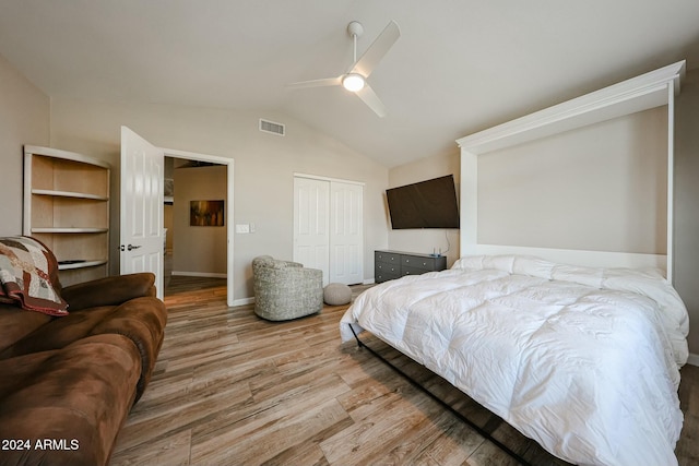 bedroom featuring light hardwood / wood-style flooring, a closet, lofted ceiling, and ceiling fan