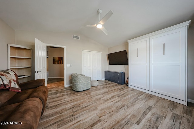 living room with ceiling fan, light hardwood / wood-style floors, and lofted ceiling