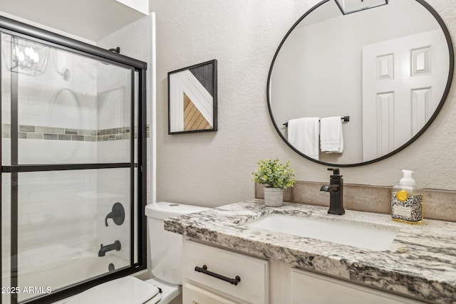 8787 E Mountain View Rd Unit 2100, Scottsdale, AZ 85258 - bathroom featuring toilet, vanity, a textured wall, and bath / shower combo with glass door