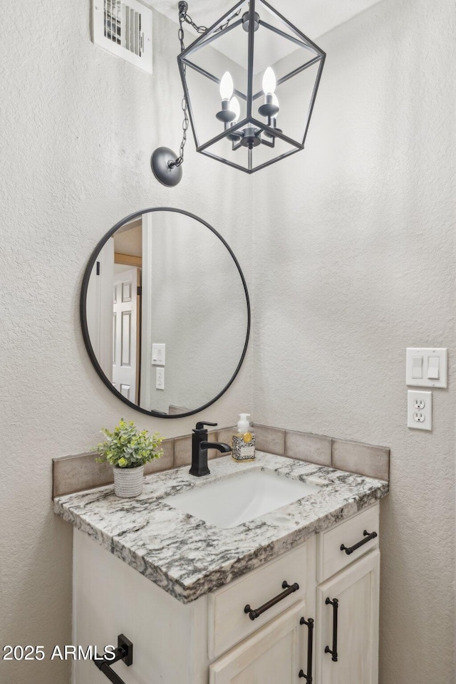 8787 E Mountain View Rd Unit 2100, Scottsdale, AZ 85258 - bathroom with vanity, a chandelier, and a textured wall