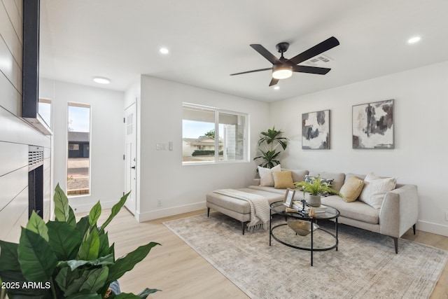 living room featuring recessed lighting, light wood-style flooring, and baseboards