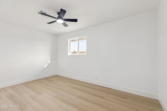 unfurnished room with visible vents, light wood finished floors, a ceiling fan, and baseboards