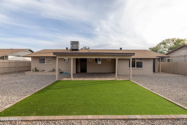 rear view of property featuring a patio, central AC, a fenced backyard, and a lawn