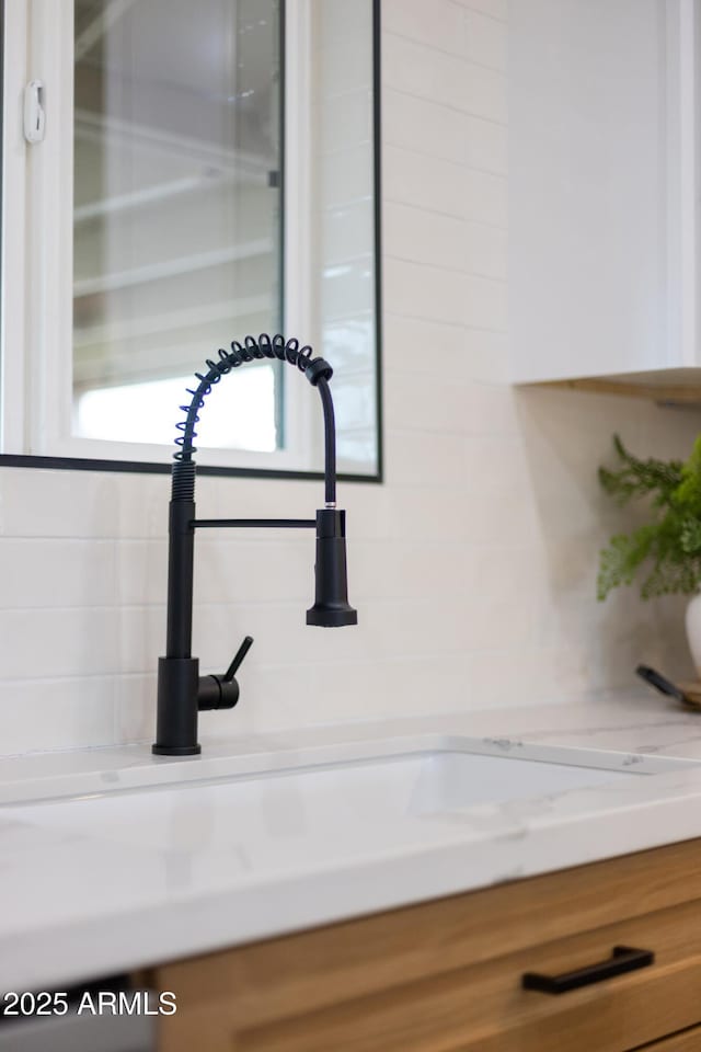 interior details featuring a sink and light stone countertops