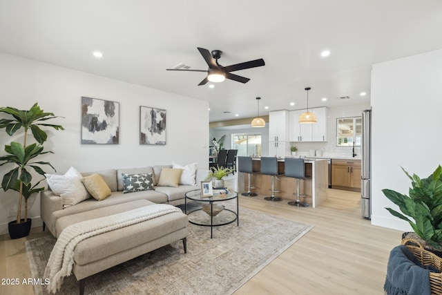 living area featuring recessed lighting, visible vents, and light wood-style floors