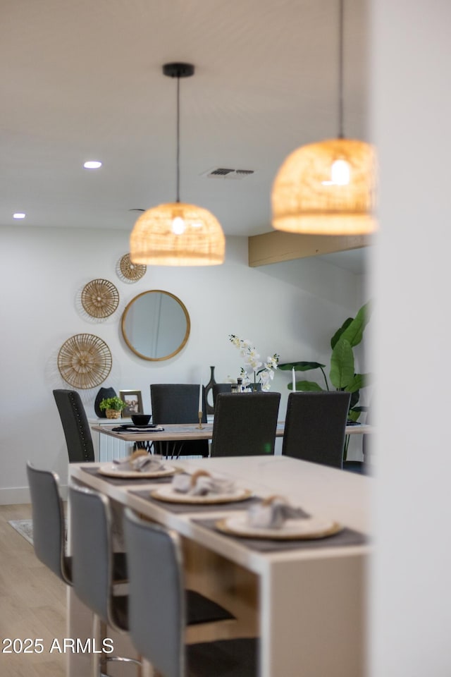 dining space featuring wood finished floors, visible vents, and recessed lighting