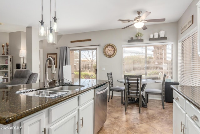 kitchen featuring dark stone countertops, dishwasher, white cabinetry, and a sink