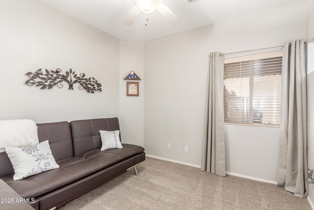 carpeted living area featuring baseboards and ceiling fan