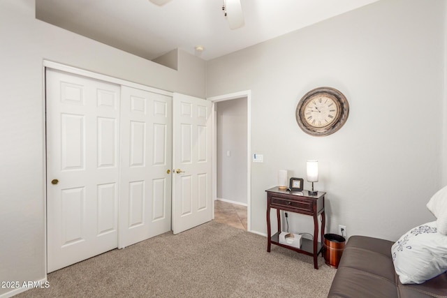 living area with a ceiling fan and carpet