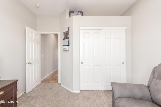 sitting room featuring light colored carpet and baseboards