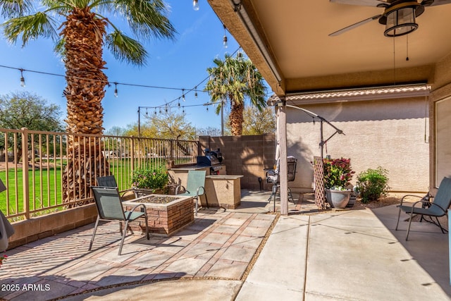 view of patio featuring fence, ceiling fan, and an outdoor fire pit