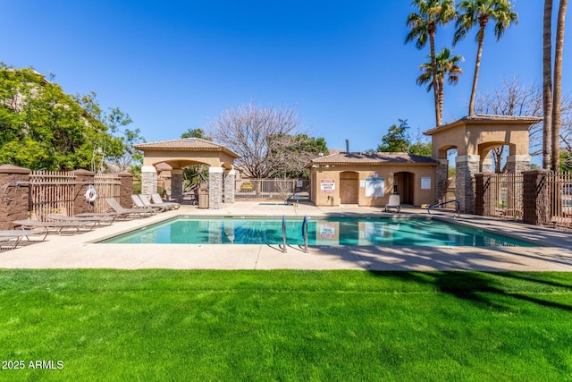 community pool with a patio area, a yard, and fence