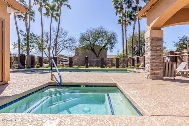 pool with a community hot tub, a patio area, and a fenced backyard