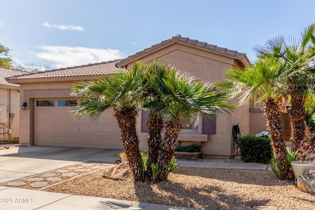 mediterranean / spanish house with stucco siding, an attached garage, driveway, and a tiled roof