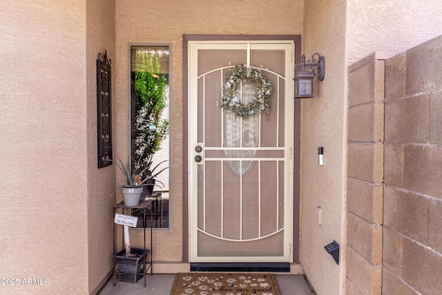 view of exterior entry featuring stucco siding