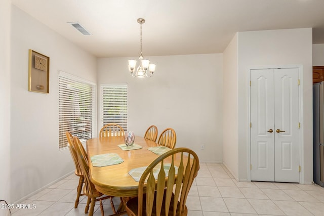 dining space with light tile patterned flooring and an inviting chandelier