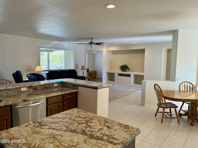 kitchen with dark brown cabinetry, ceiling fan, stainless steel dishwasher, a textured ceiling, and light tile patterned floors