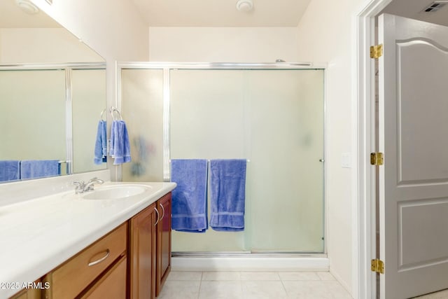 bathroom with tile patterned floors, vanity, and an enclosed shower