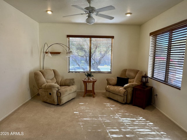 sitting room featuring light colored carpet and ceiling fan