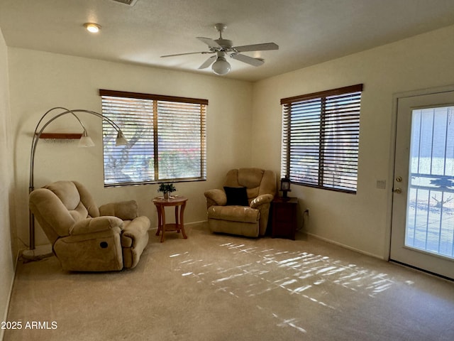 sitting room with carpet flooring, a wealth of natural light, and ceiling fan