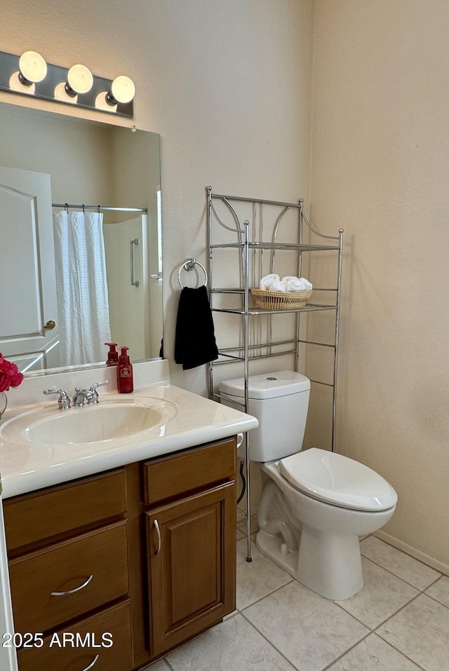 bathroom with tile patterned flooring, vanity, toilet, and walk in shower