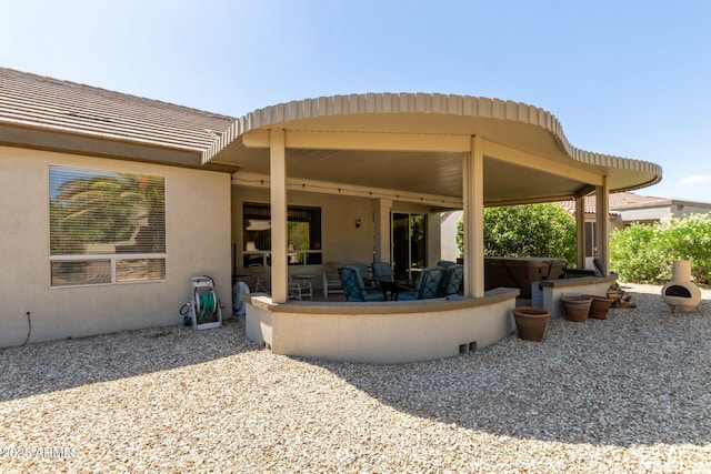 rear view of property with a jacuzzi and a patio