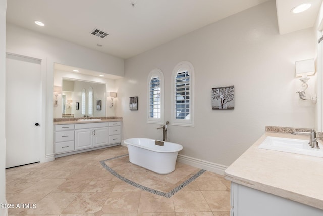 bathroom featuring two vanities, a sink, visible vents, and baseboards