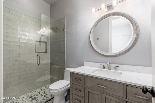 bathroom featuring a stall shower, vanity, and toilet