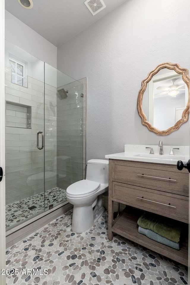 full bath with visible vents, a shower stall, toilet, and vanity