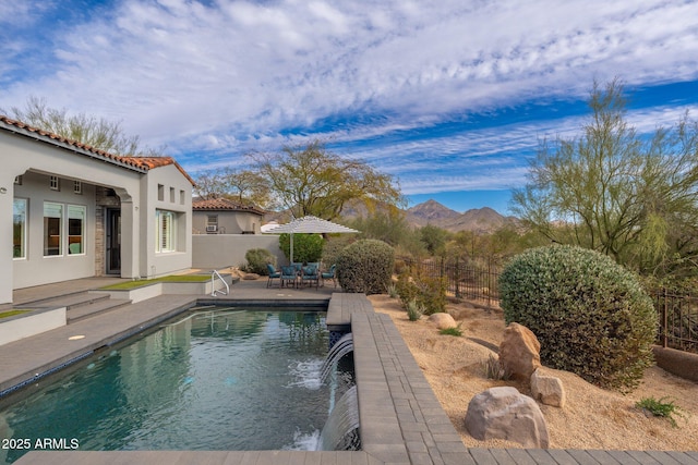 view of pool featuring a fenced in pool, a fenced backyard, a mountain view, and a patio