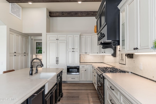 kitchen with oven, exhaust hood, a sink, light countertops, and gas stove