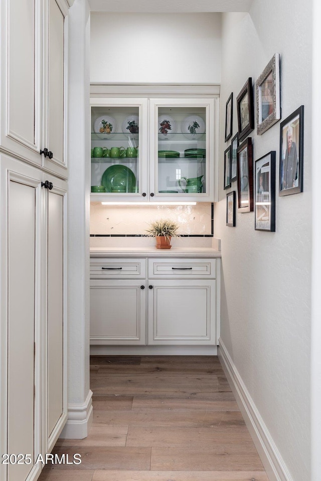 bar with light wood-type flooring and baseboards