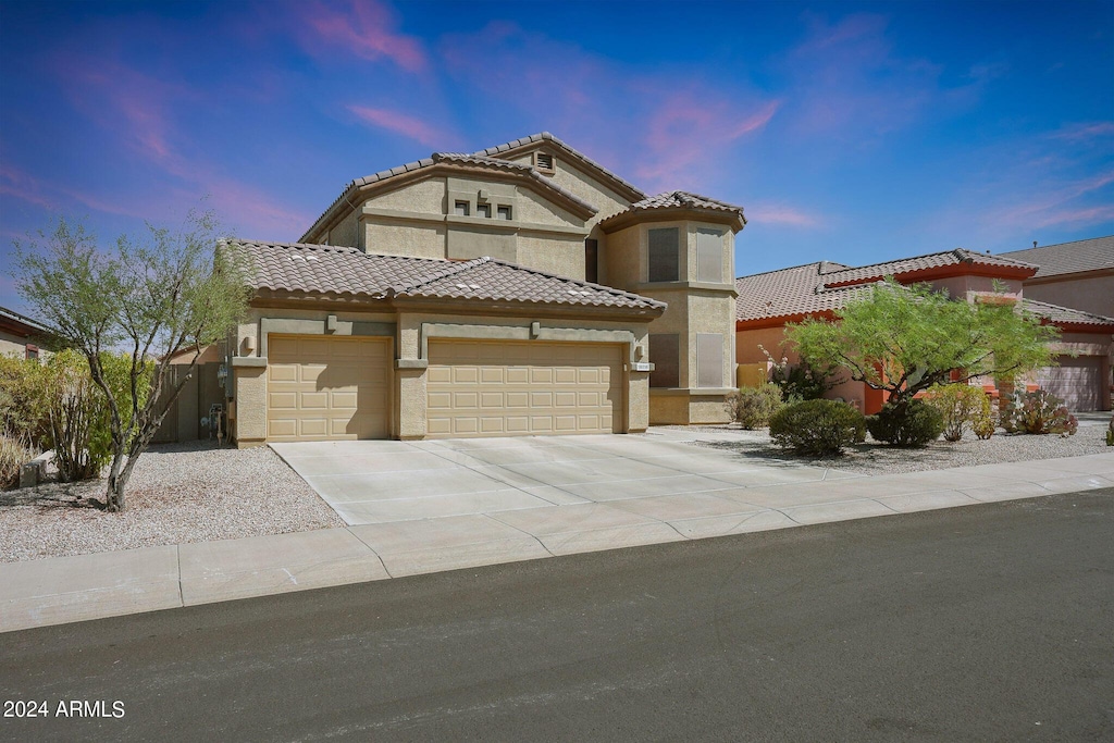 18516 W Sweet Acacia Dr, Goodyear, AZ 85338 - mediterranean / spanish-style house featuring a garage, stucco siding, driveway, and a tile roof