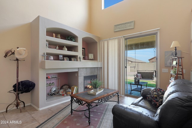 living room featuring built in shelves, light tile patterned flooring, and a fireplace